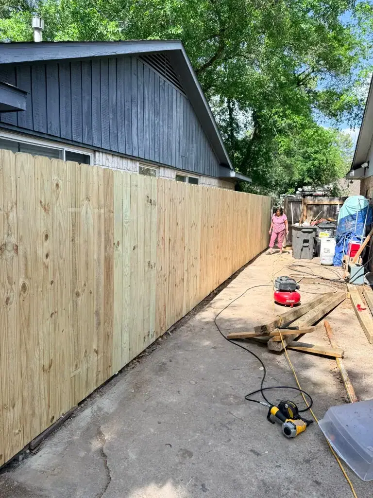 Vista de una cerca de madera recién instalada junto a una casa.
